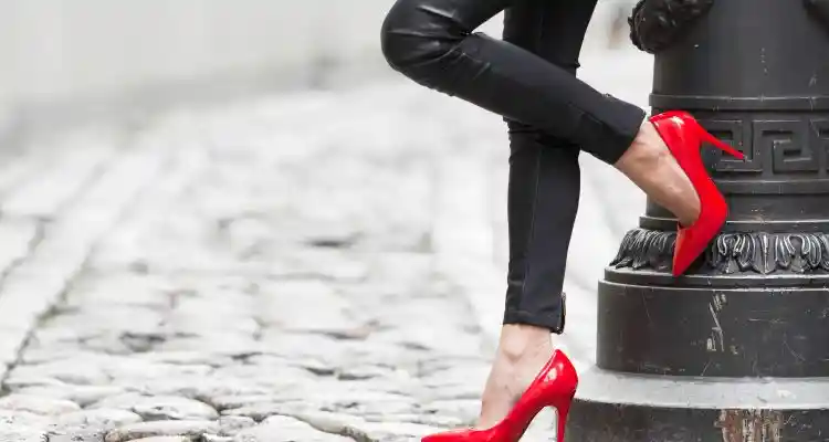 Women wearing black leather pants and red high heels