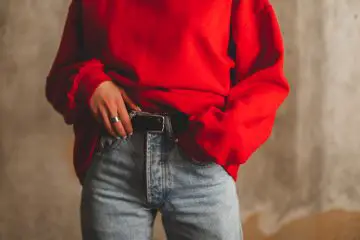 Women wearing red sweater with high waisted jeans and black belt