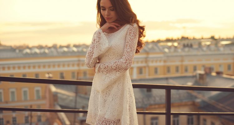 A women wearing white short lace dress with her hair open looking beautiful
