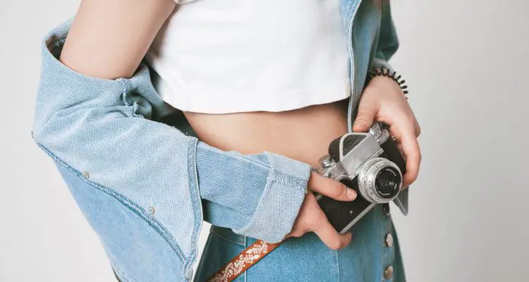 White crop top and short denim skirt with camera.