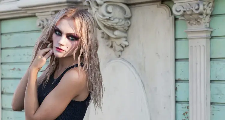 A fashion gothic style portrait of a beautiful blonde girl outside