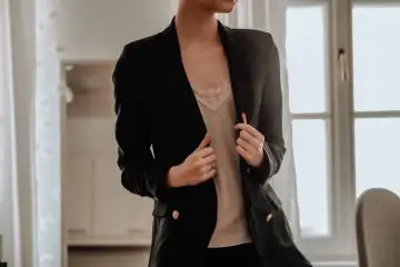 Women wearing black blazer with cream satin blouse