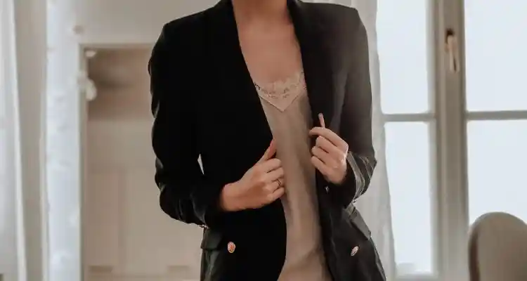 Women wearing black blazer with cream satin blouse