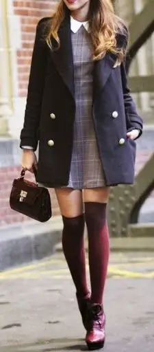 Society 19. Women wearing navy coat and plaid dress with boots
