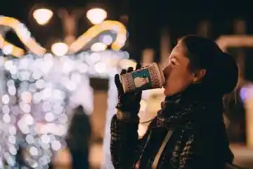 Women drinking hot chocolate with winter clothes and gloves