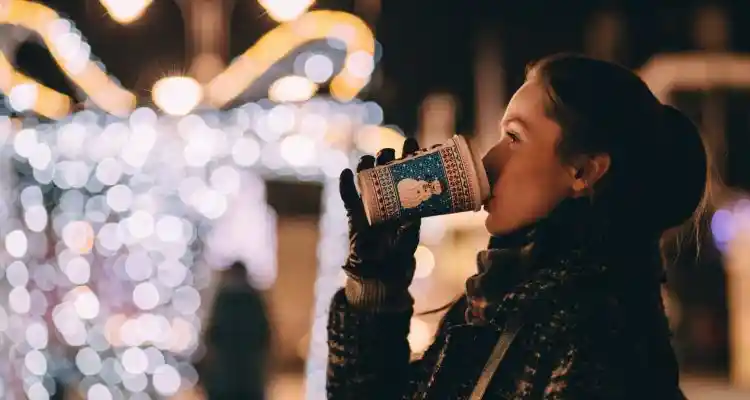 Women drinking hot chocolate with winter clothes and gloves