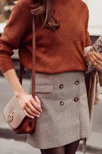 Mode and the City. Women wearing a check a-line skirt with brown sweater and tan handbag