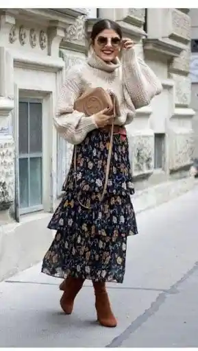 Women wearing boho chic skirt and beige turtleneck and retro sunglasses with tan boots