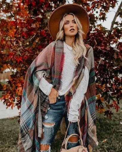 Women wearing boho chic poncho with chunky sweater and jeans with a hat