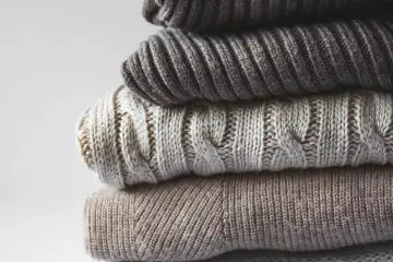 pile of grey winter warm sweaters
