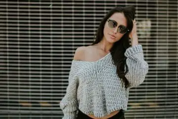 woman wearing black jeans and off the shoulder sweater with sunglasses