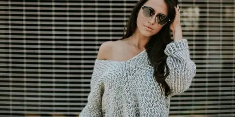 woman wearing black jeans and off the shoulder sweater with sunglasses