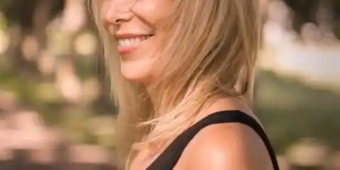 woman with short blonde hair wearing a black tank top